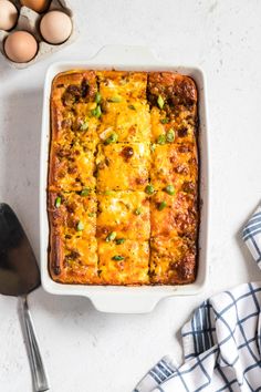 an enchilada casserole with meat and cheese in a white dish