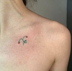 a woman's chest with a small tattoo on the left side of her breast