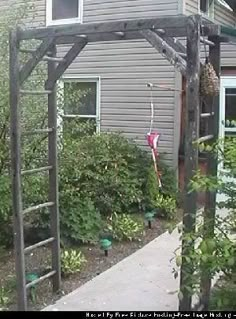 an outside view of a house with a wooden pergolated structure and plants in the foreground