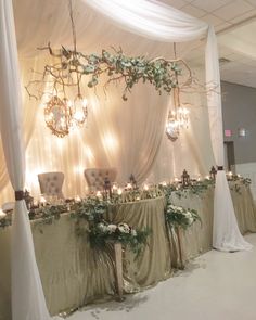 an elegant wedding setup with chandeliers and greenery