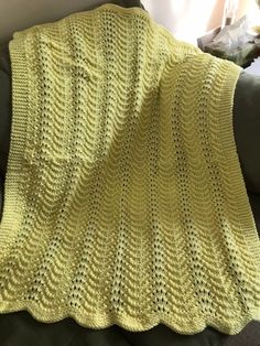 a yellow crocheted blanket sitting on top of a couch