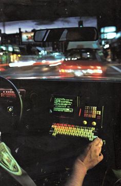 a man driving a bus at night with his hand on the steering wheel and keyboard