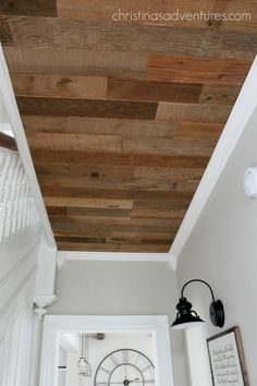 the ceiling is made from wood planks and has a clock hanging on it's side