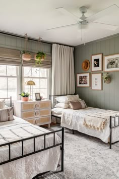 a bedroom with two beds and pictures on the wall