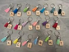 a bunch of key chains with letters and tassels attached to them that spell out words