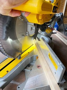 a person using a circular saw to cut wood