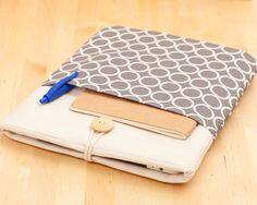 an ipad case is sitting on the floor with a blue pen and pencil in it