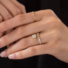 a woman's hand with two gold rings and one diamond ring on her finger