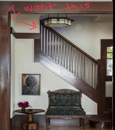 an entry way with a bench, table and stairs