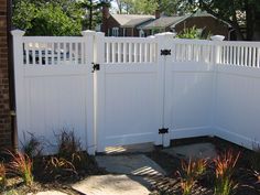 a white fence with two gates in front of it