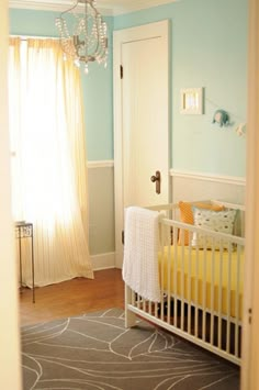 a baby's room with a crib and chandelier