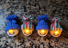 three light - up faces are sitting on a granite surface with lights in the shape of people's heads