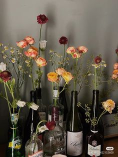 several bottles with flowers in them sitting on a table