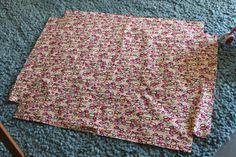 a flowery blanket laying on the floor next to a chair