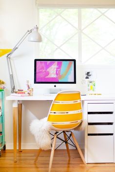 a desk with a computer on top of it and a chair in front of it