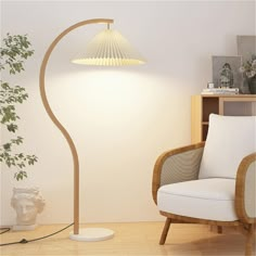 a white chair sitting next to a lamp on top of a wooden floor in a living room