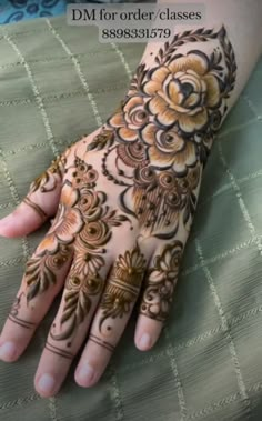 a woman's hand with hennap on it and flowers painted on the palm