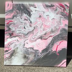 a pink and black painting on the ground next to a white car with it's door open