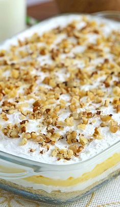 a casserole dish filled with whipped cream and walnuts, on a table