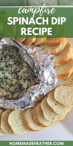 a white plate topped with bread and spinach dip next to crackers on a table