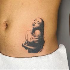 a woman's stomach with a tattoo of a girl on the side and her face