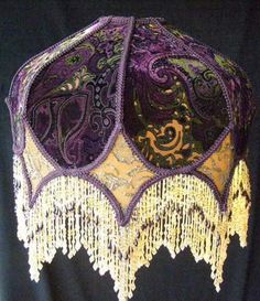 an ornate purple and gold lamp shade on a mannequin headdress,