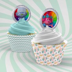 two cupcakes with frosting and characters in the top one has a rainbow swirl