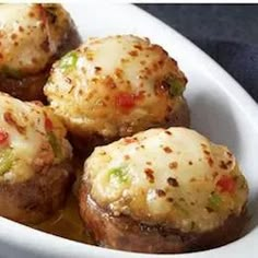 several stuffed mushrooms in a white dish on a table