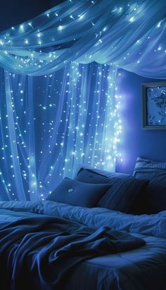 a bed covered in white lights under a blue canopy over it's headboard