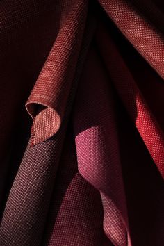 red and purple fabric folded together on top of each other in close up detail view