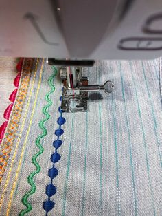 the sewing machine is stitching on the fabric with it's needle and thread