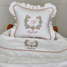 a white bed topped with pillows and a pillow case