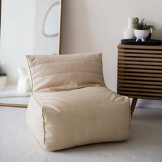 a beige chair sitting in front of a mirror