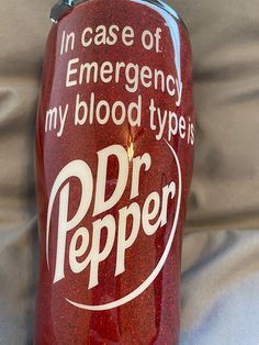 there is a red plastic bottle with white writing on it that says, in case of emergency my blood type is dr pepper