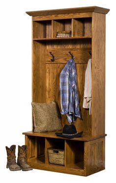 a wooden bench with a hat, coat rack and boots next to it on the floor