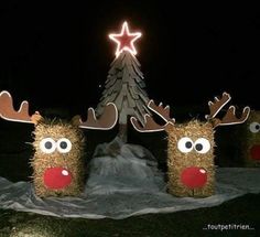 three hay wrapped reindeers are standing in front of a christmas tree with a star on top