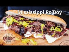 a sandwich with meat, onions and cheese on a cutting board that says mississippi po boy