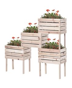 three wooden planters with red flowers in them