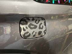 an animal print window sticker on the side of a car with people in the background