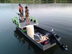 two men standing on the back of a small boat