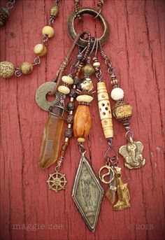 an assortment of jewelry is displayed on a wooden surface with beads, charms and pendants