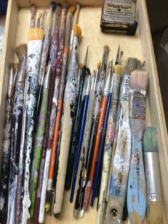 an open box filled with lots of paint brushes