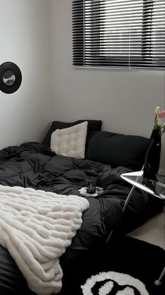 a black and white room with a bed, couch, table and flowers on the floor