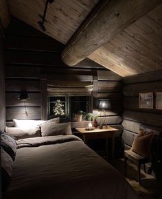 a bed sitting under a wooden ceiling next to a window in a room with wood walls