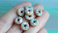 there are many donuts that have sprinkles on them in someone's hand