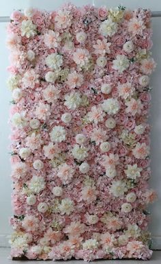 a large flowered wall hanging on the side of a white wall with pink and white flowers