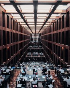 an office filled with lots of desks and people sitting at their computers in rows