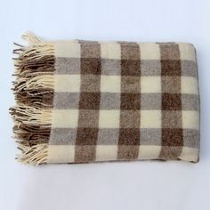 a brown and white checkered blanket laying on top of a table