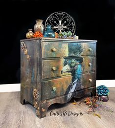 an old dresser with a painting on the front and drawers painted to look like a bird