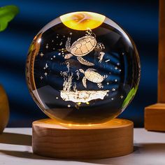 a glass ball with an image of sea animals in the ocean inside it on a wooden stand